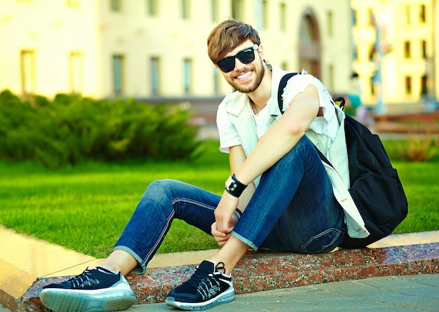 Portrait of handsome man in stylish hipster clothes. Attractive guy posing in the street