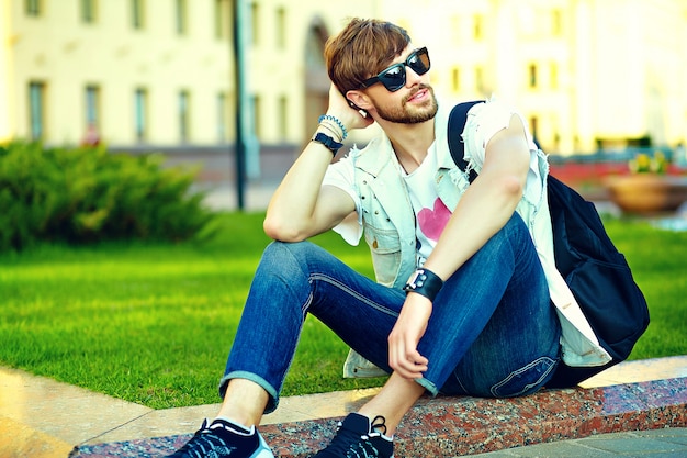 Ritratto di uomo bello in abiti eleganti hipster. ragazzo attraente in posa in strada