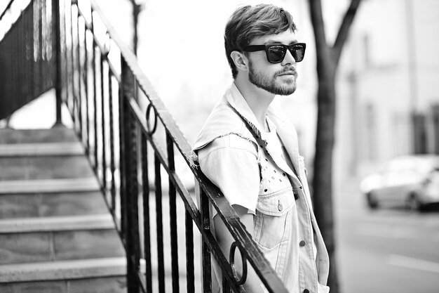 Portrait of handsome man in stylish hipster clothes. Attractive guy posing in the street