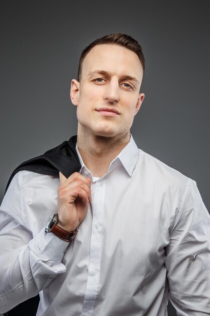 Portrait of handsome man in white shirt with wrist watch on his hand