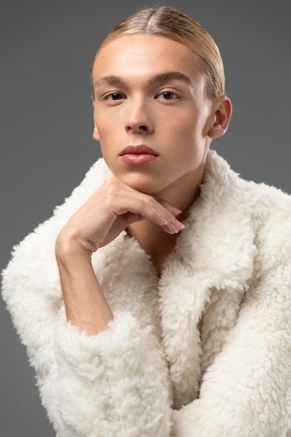 Portrait of handsome man with long blonde hair and fluffy jacket