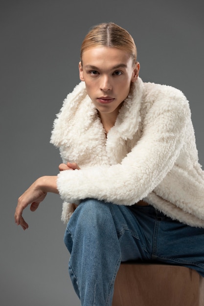 Portrait of handsome man with long blonde hair and fluffy jacket