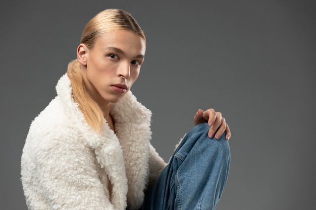 Free photo portrait of handsome man with long blonde hair and fluffy jacket