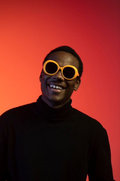 Free photo portrait of handsome man with sunglasses over orange background