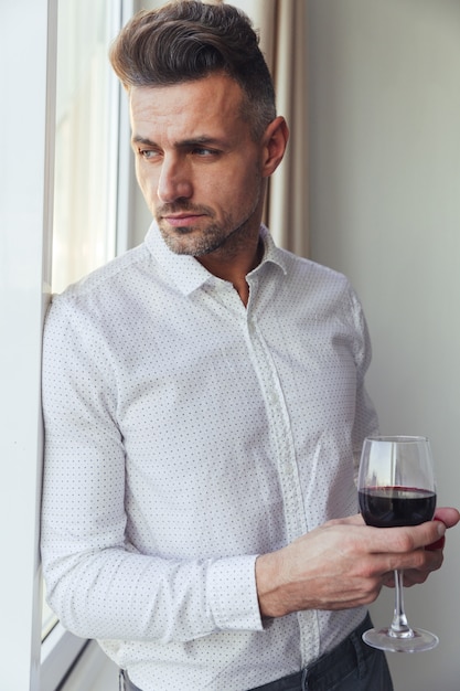 Foto gratuita il ritratto di un uomo pensieroso bello si è vestito in camicia