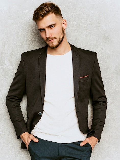 Portrait of handsome serious hipster   businessman model wearing casual black suit.