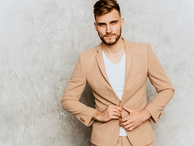 Portrait of handsome serious modern hipster   businessman model wearing casual beige suit.