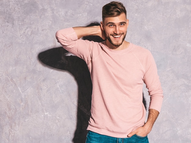 Portrait of handsome smiling hipster   businessman model wearing casual summer pink clothes.