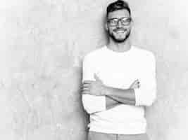 Free photo portrait of handsome smiling hipster   businessman model wearing casual summer white clothes . crossed arms