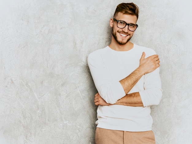 Portrait of handsome smiling hipster   businessman model wearing casual summer white clothes.