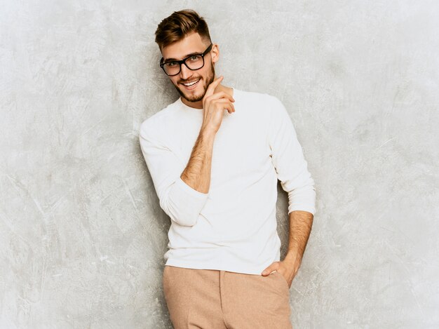 Portrait of handsome smiling hipster   businessman model wearing casual summer white clothes 