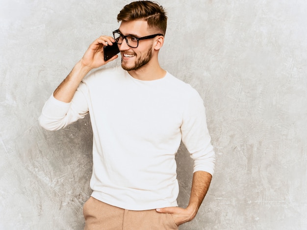 Portrait of handsome smiling hipster   businessman model wearing casual summer white clothes.  