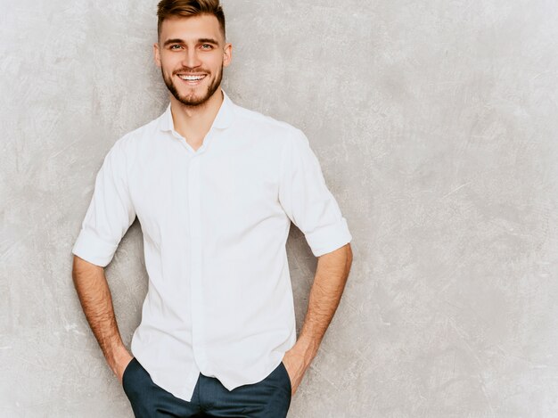 Portrait of handsome smiling hipster  businessman model wearing casual summer white shirt. 