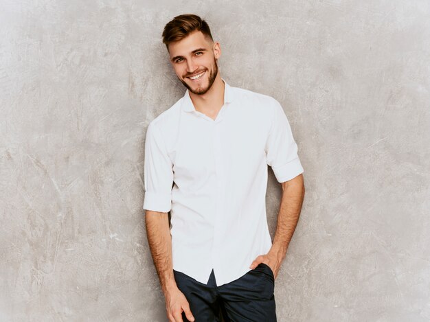 Portrait of handsome smiling hipster  businessman model wearing casual summer white shirt. 
