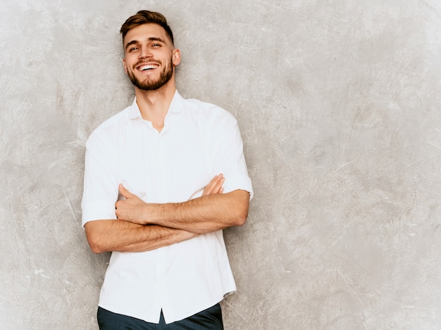 Portrait of handsome smiling hipster  businessman model wearing casual summer white shirt. 