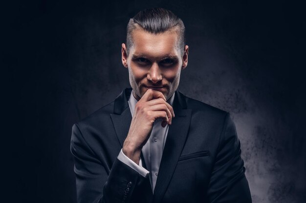 A portrait of handsome, smiling stylish businessman over a dark background.