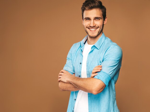 Portrait of handsome smiling stylish young man model dressed in jeans clothes. Fashion man. Posing