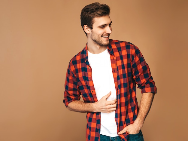 잘 생긴 웃는 세련 된 젊은 남자 모델의 초상화는 빨간색 체크 무늬 셔츠를 입은. 패션 남자 포즈