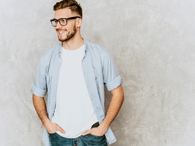 Portrait of handsome smiling young man model wearing casual shirt clothes. Fashion stylish man posing in spectacles