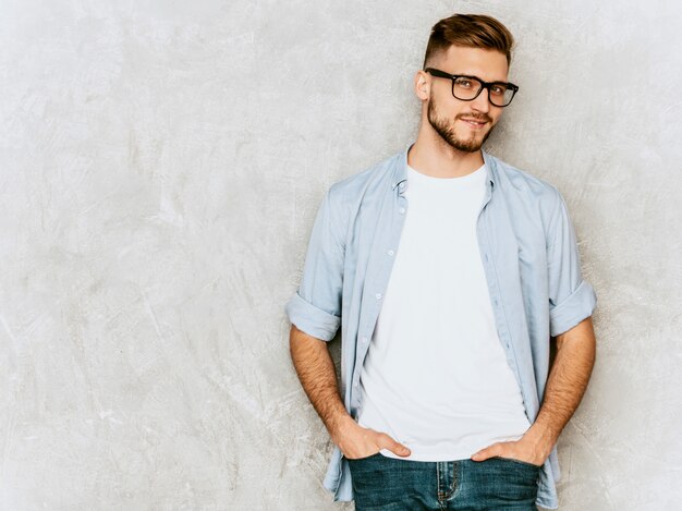 Portrait of handsome smiling young man model wearing casual shirt clothes. Fashion stylish man posing in spectacles