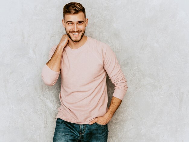 Портрет красивый улыбающийся молодой человек модели носить повседневные летние розовые одежды. Мода стильный мужчина позирует
