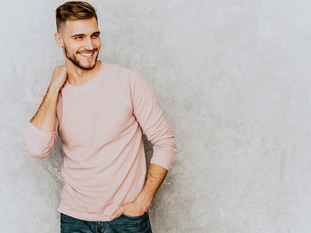 Portrait of handsome smiling young man model wearing casual summer pink clothes. Fashion stylish man posing