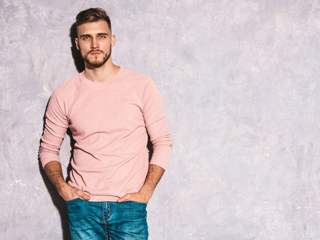 Портрет красивый улыбающийся молодой человек модели носить повседневные летние розовые одежды. Мода стильный мужчина позирует
