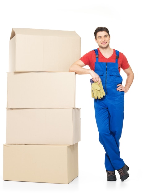 Portrait of handsome young delivery man with paper boxes isolated on white