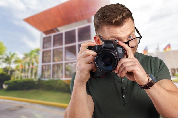 Portrait of a handsome young in glasses man with camera