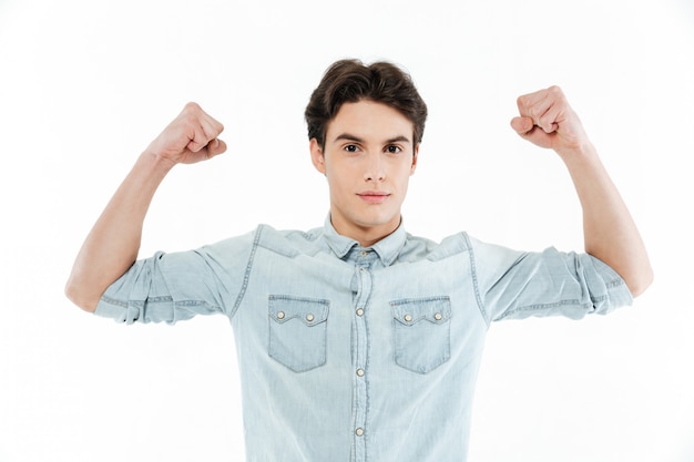 Portrait of a handsome young guy flexing bicep muscles