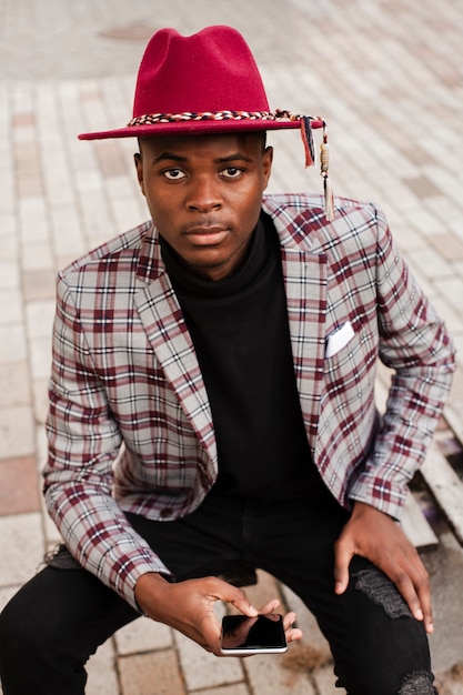 Portrait of handsome young male holding mobile phone