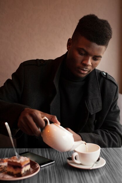 Portrait of handsome young man having tea