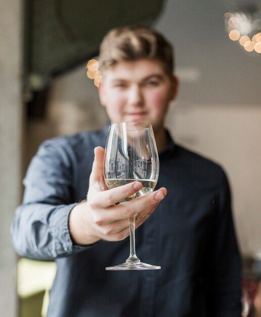 Foto gratuita ritratto del giovane bello che tiene un drink