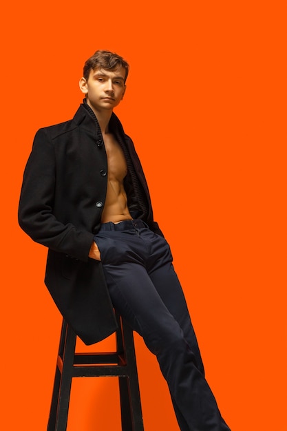 Portrait of a handsome male model posing shirtless in a brown leather  jacket and jeans. Grey Stock Photo by Gerain0812