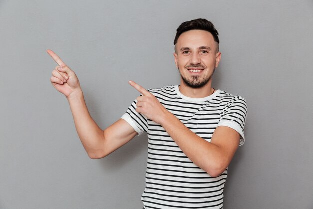 Portrait of a handsome young man pointing two fingers