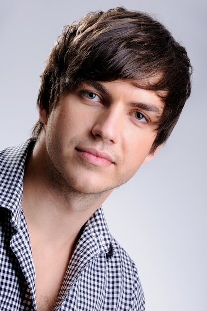 Portrait of a handsome young man posing in the studio with modern straight hairstyle