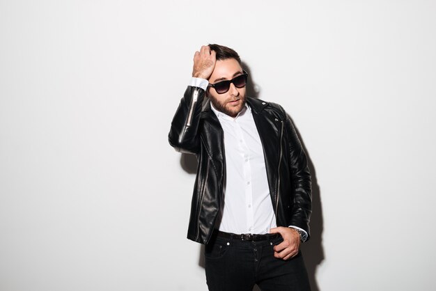 Portrait of a handsome young man in sunglasses posing