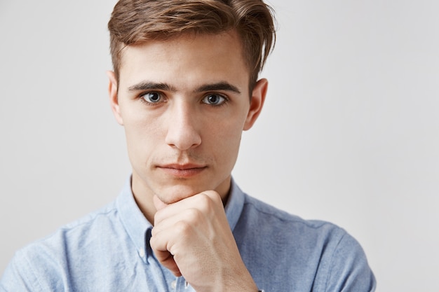 Portrait of handsome young man with hand on chin