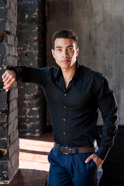 Portrait of a handsome young man with his hand in pocket looking at camera