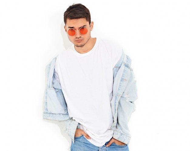 Portrait of handsome young model man dressed in jeans clothes in sunglasses posing. Isolated