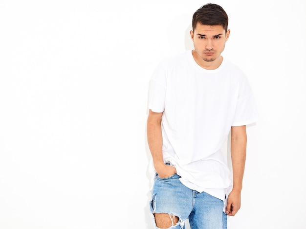 Portrait of handsome young model man dressed in jeans clothes  and T-shirt posing. Crossed arms