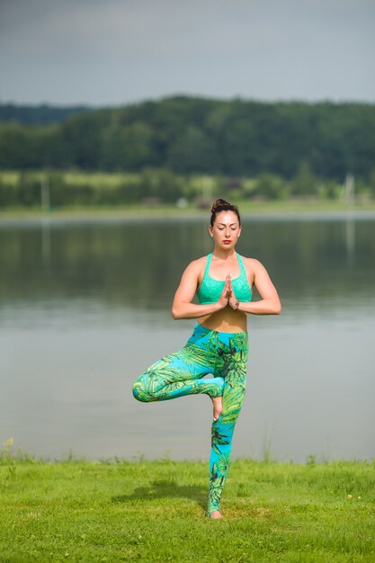 Портрет счастья молодой женщины, практикующей йогу на открытом воздухе