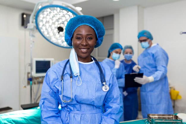 Portrait of happy African American woman surgeon standing in operating room ready to work on a patient Female medical worker in surgical uniform in operation theater