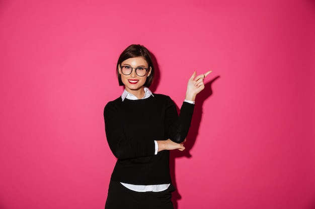 Portrait of a happy attractive businesswoman pointing