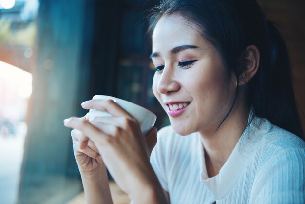 Portrait of happy beautiful female with mug in hands