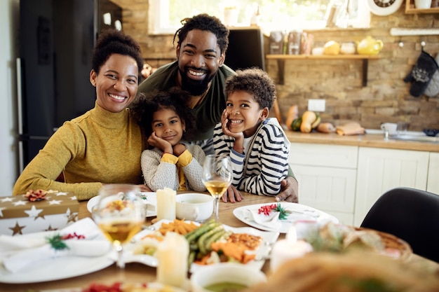 portrait of happy black family during christmas lunch in dining room