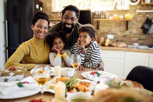 Portrait of happy black family during Christmas lunch in dining room