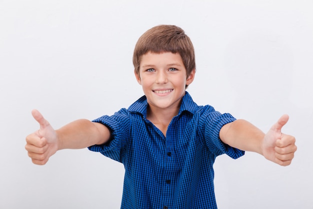 Free photo portrait of happy boy showing thumbs up gesture