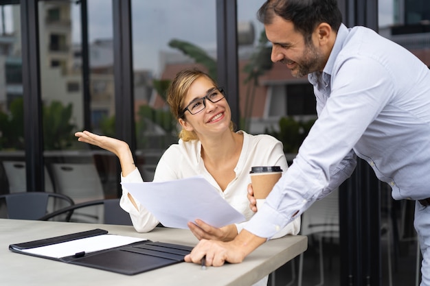 Portrait of happy business colleagues discussing papers