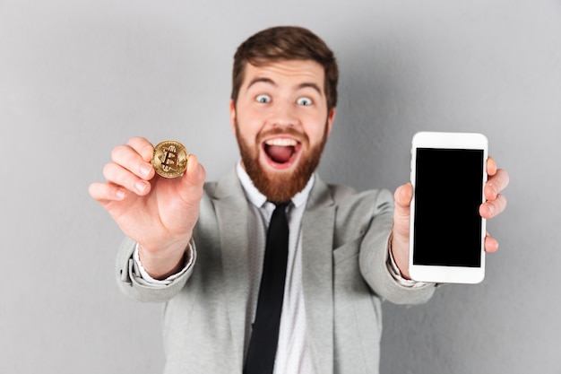 Free photo portrait of a happy businessman holding bitcoin